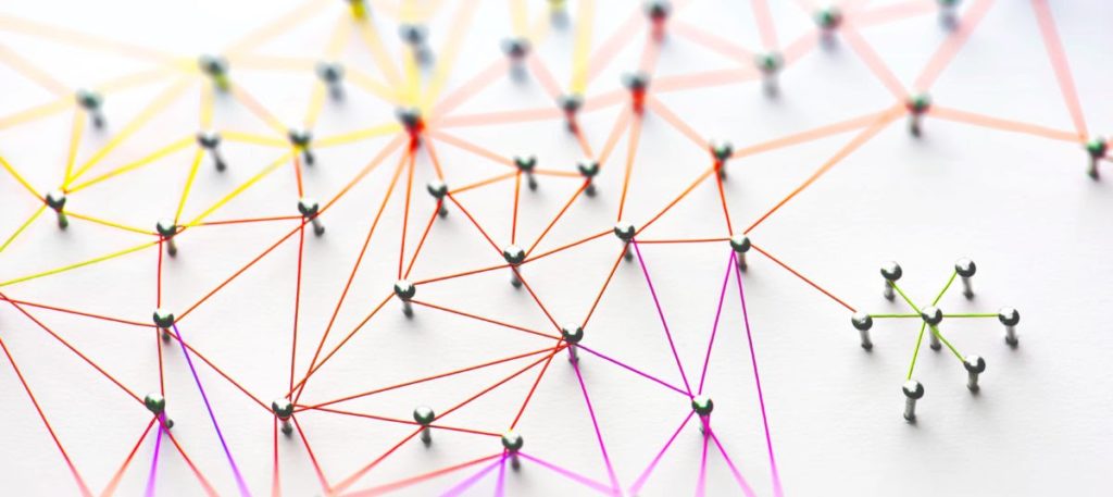 A connected network of nails with multicoloured string.