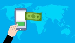 A cartoon depiction of money being sent from a mobile phone with a map of the world in the background.