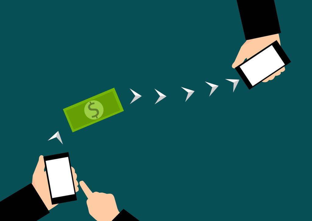 A cartoon depiction of money being transferred between two cellphones.